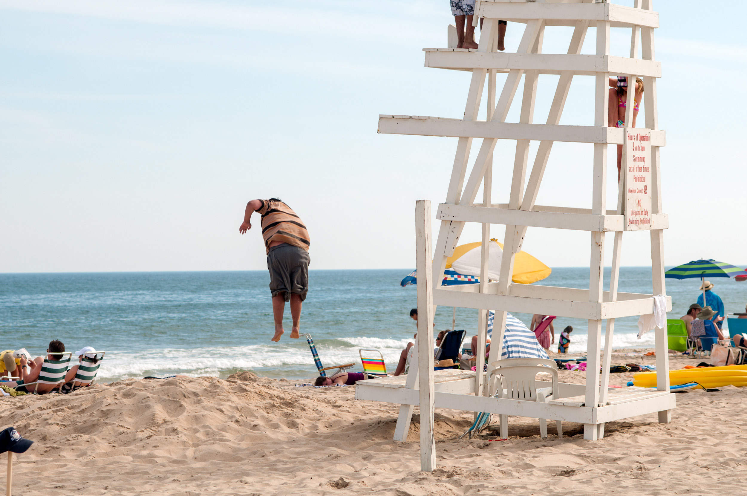 A-CHILD-HANGS-MID-AIR-AFTER-JUMPING-FROM-A-LIFEGUARD-CHAIR-IN-FIREISLAND-USA