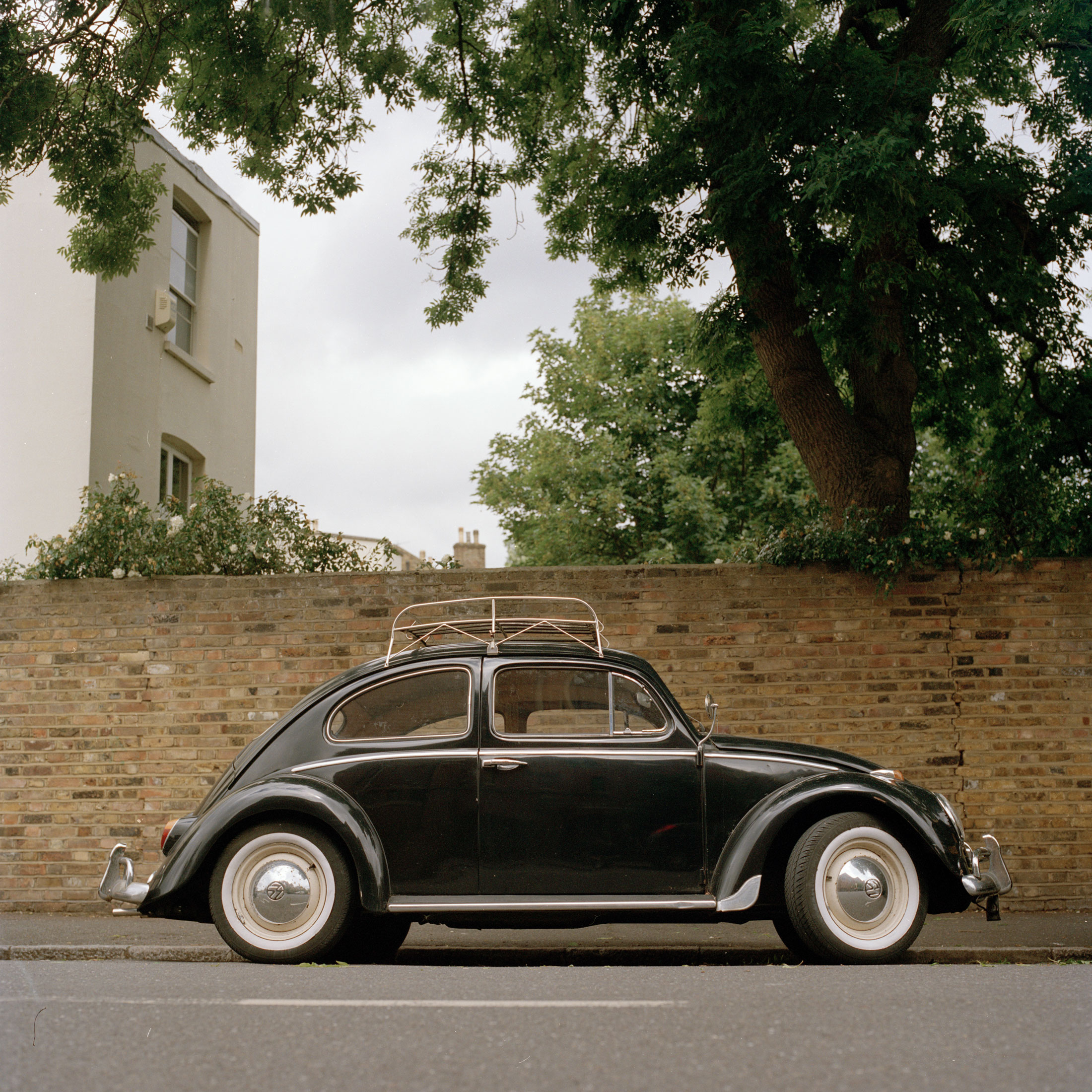 A black volkswagon Beetle sits on a Stoke Newington Street in London, UK. 