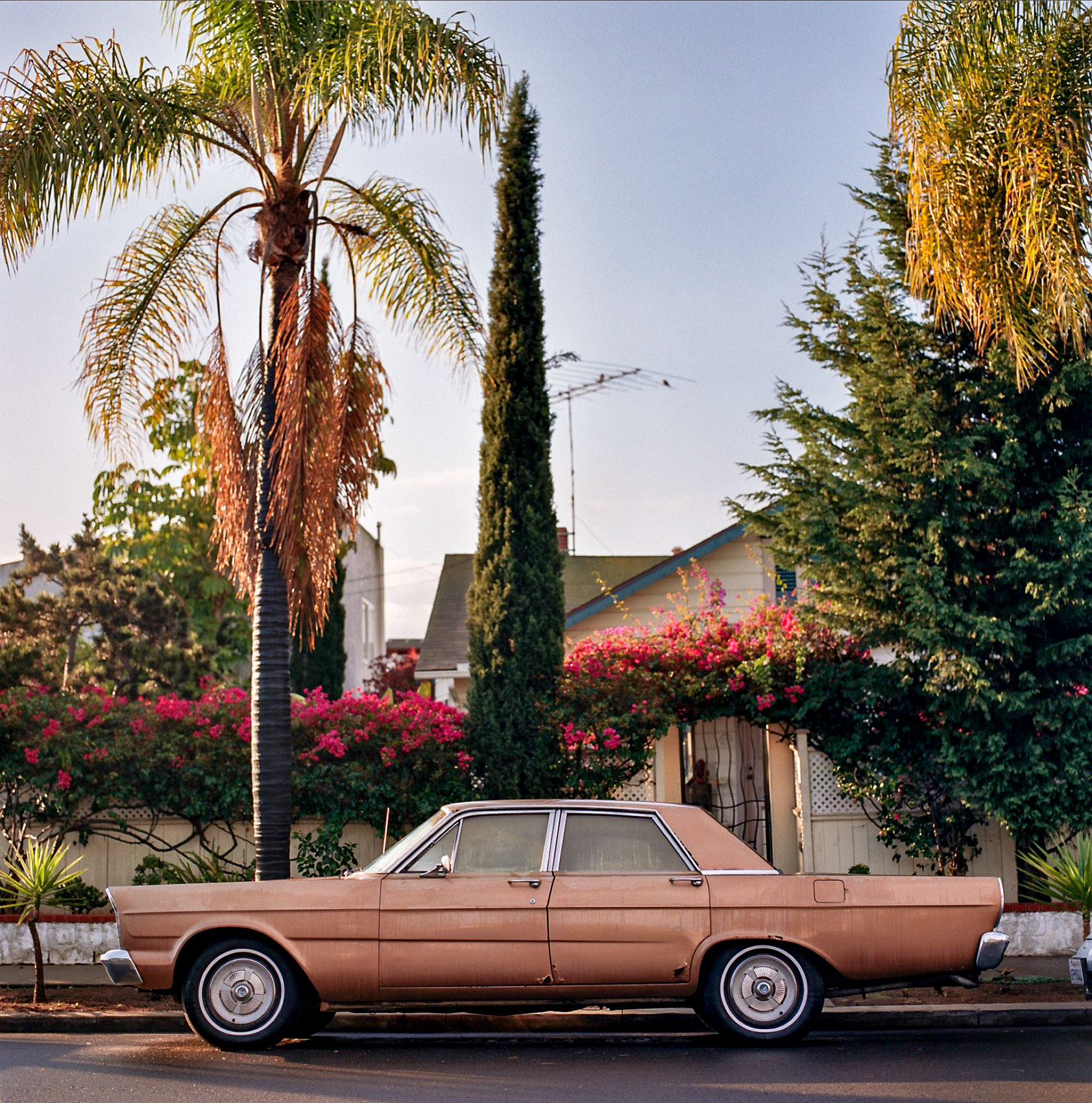 A-CLASSIC-VINTAGE-CAR-SITS-ON-A-STREET-IN-SAN-DIEGO-DURING-SUNRISE-IN-CALIFORNIA