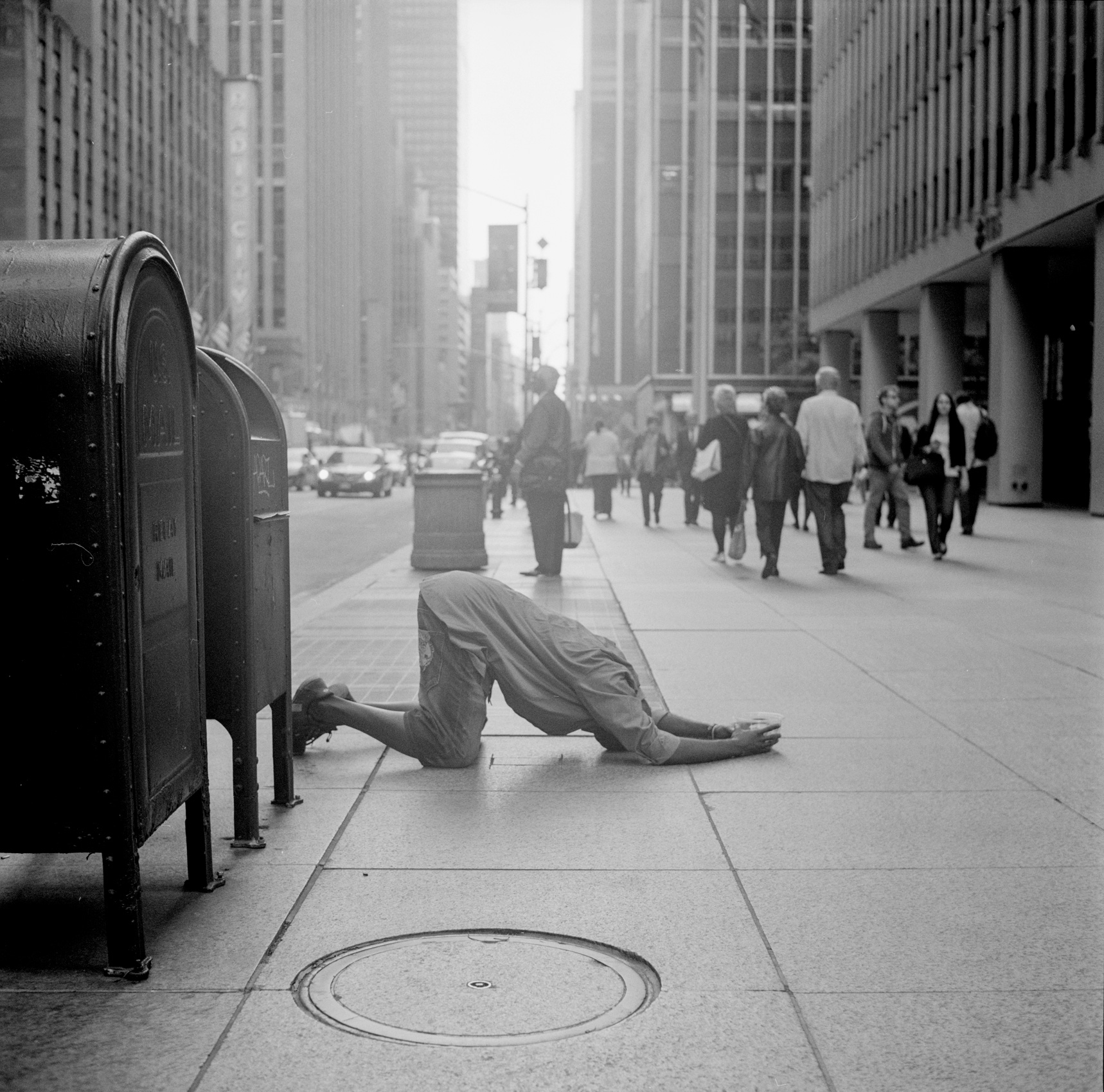 A man uses the sidewalk to pray while on a busy Manhttan sidewalk in Midtown, New York City
