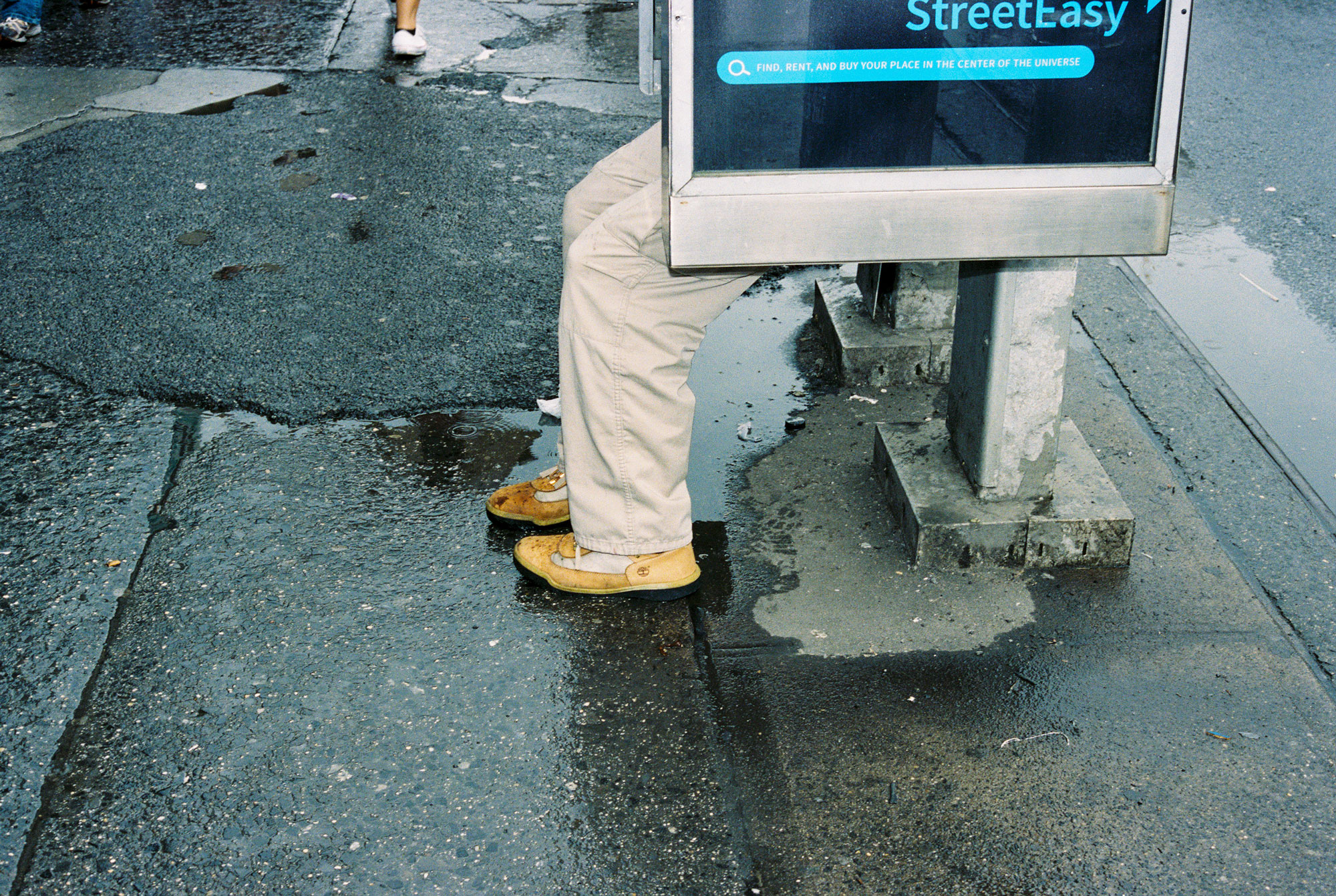 AN-IMAGE-OF-FEET-HANGING-OUT-OF-A-PHONE-BOOTH-IN-THE-STREETS-OF-NEW-YORK-CITY