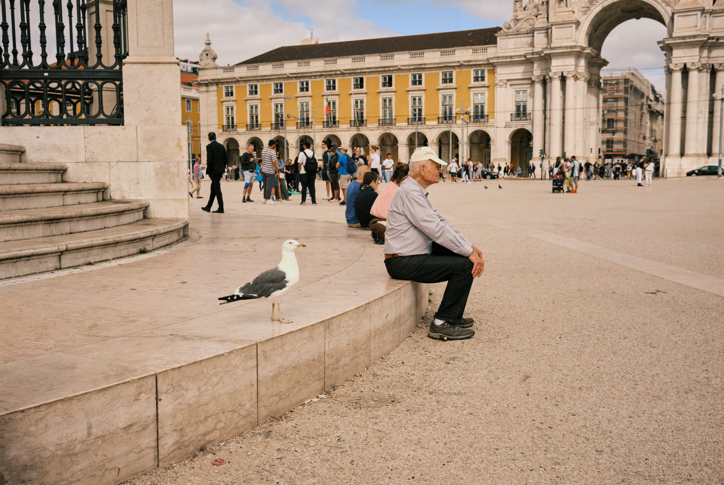 AN-OLD-MAN-SITS-IN-THE-MIDDLE-OF-Praca-do-Comercio-LISBON-PORTUGAL
