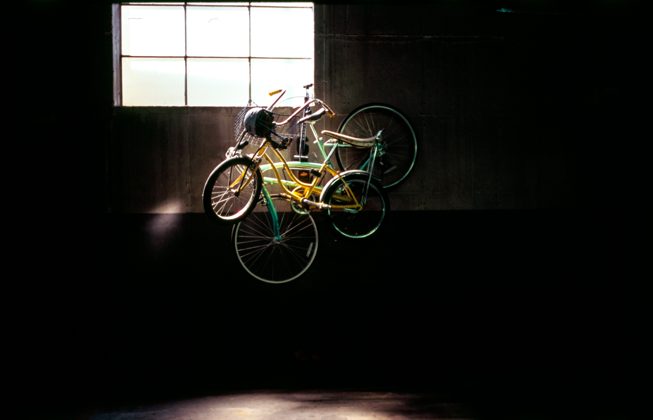 BIKES-HANG-IN-A-PARKING-LOT-GARAGE-ILLUMINATED-BY-THE-WINDOW