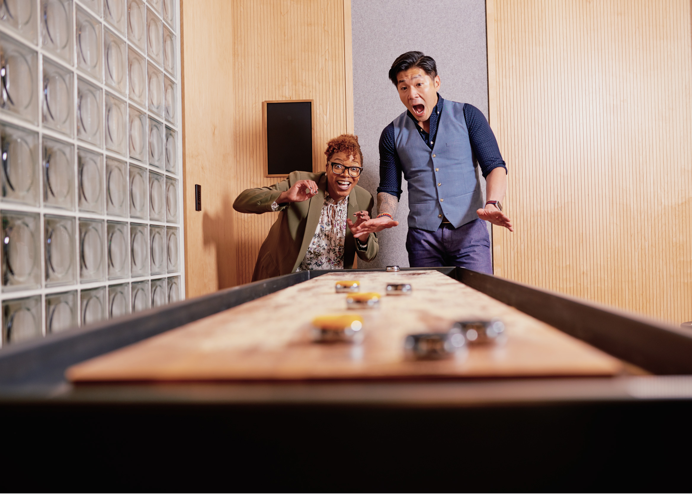 TWO TEAM MEMBERS PLAY SHUFFLEBOARD AT GENERAL INFORMATION SECURITY DEPARTMENT BANK OF AMERICA