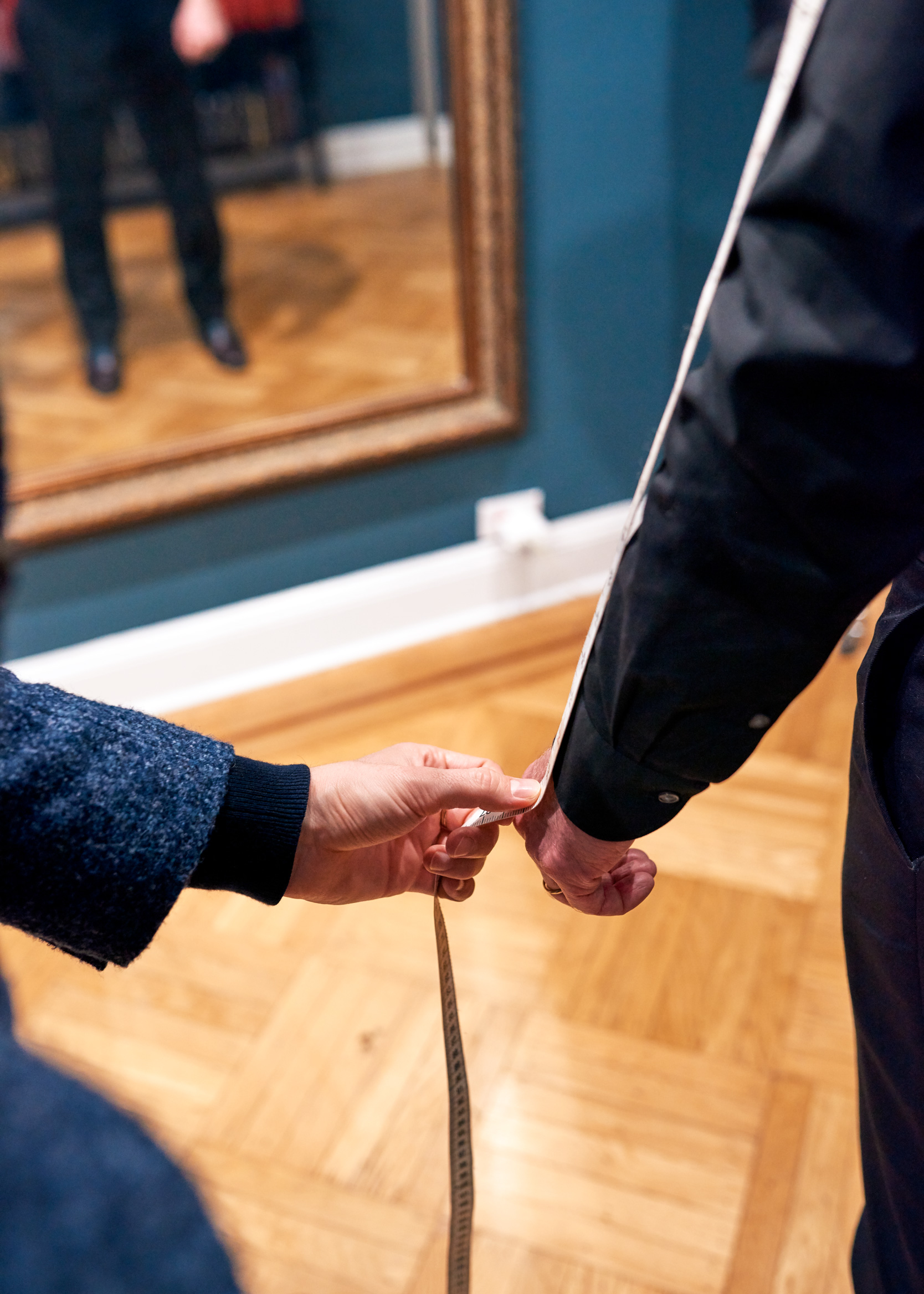 A MEASUREMENT IS TAKEN ON SOMEONE"S SLEEVE AT THE SHOWROOM OF CAD AND THE DANDY