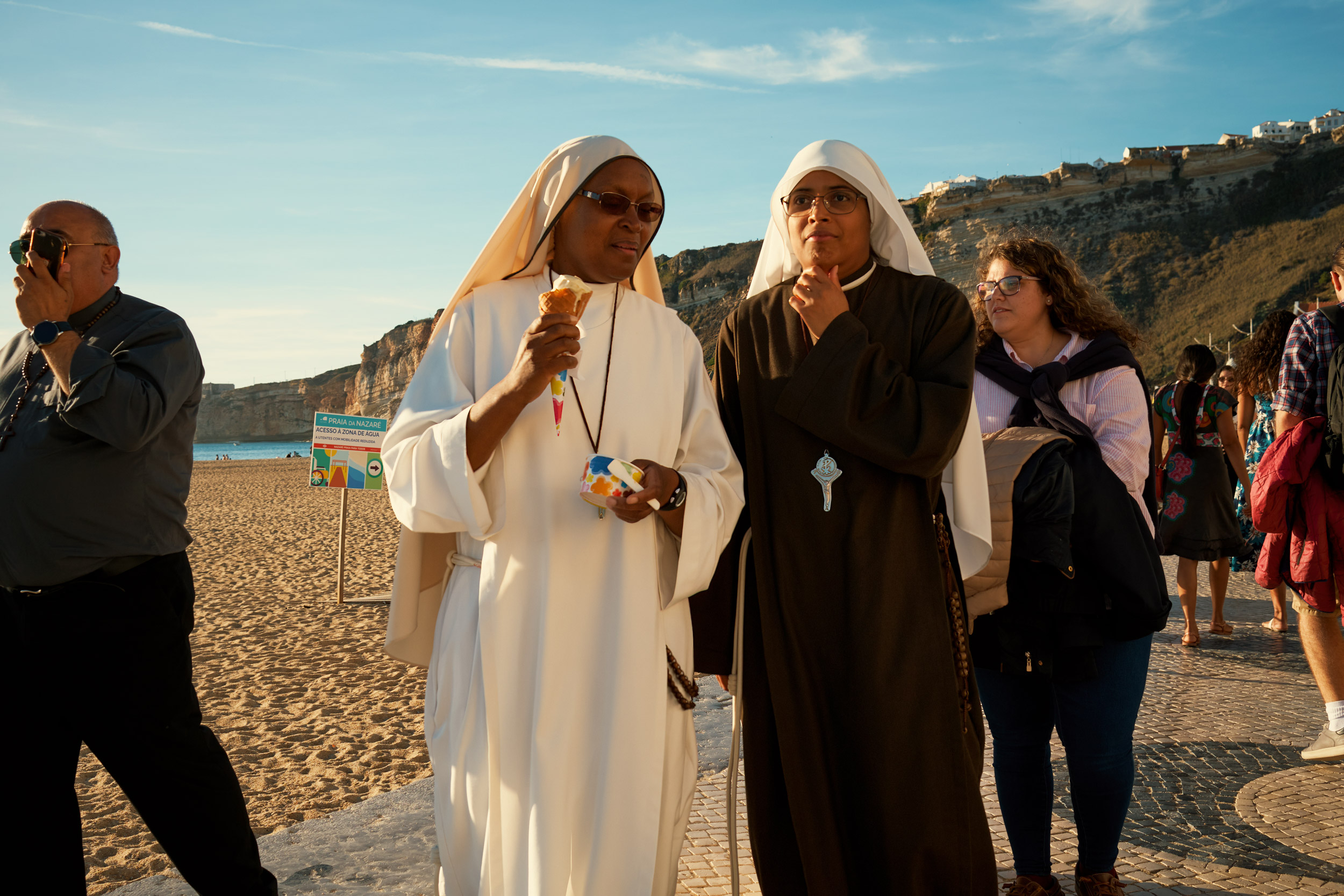 TWO-NUNS-WALK-WITH-ICE-CREAMS-ALONG-THE-BEACH-FRONT-IN-NARARE-PORTUGAL