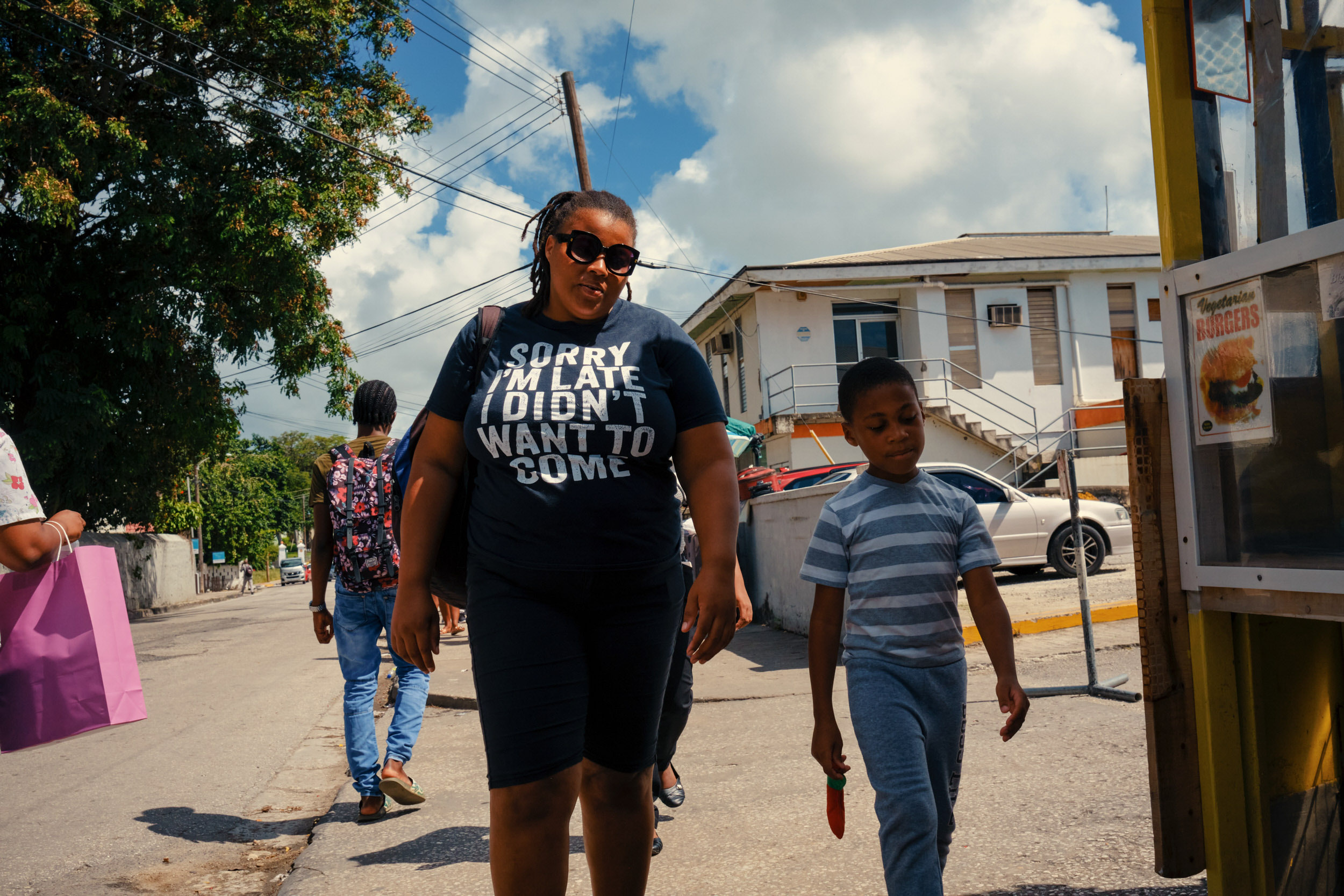 A MOTHER AND CHILD WALK THROUGH THE STREETS OF BRIDGETOWN IN BARBADOS