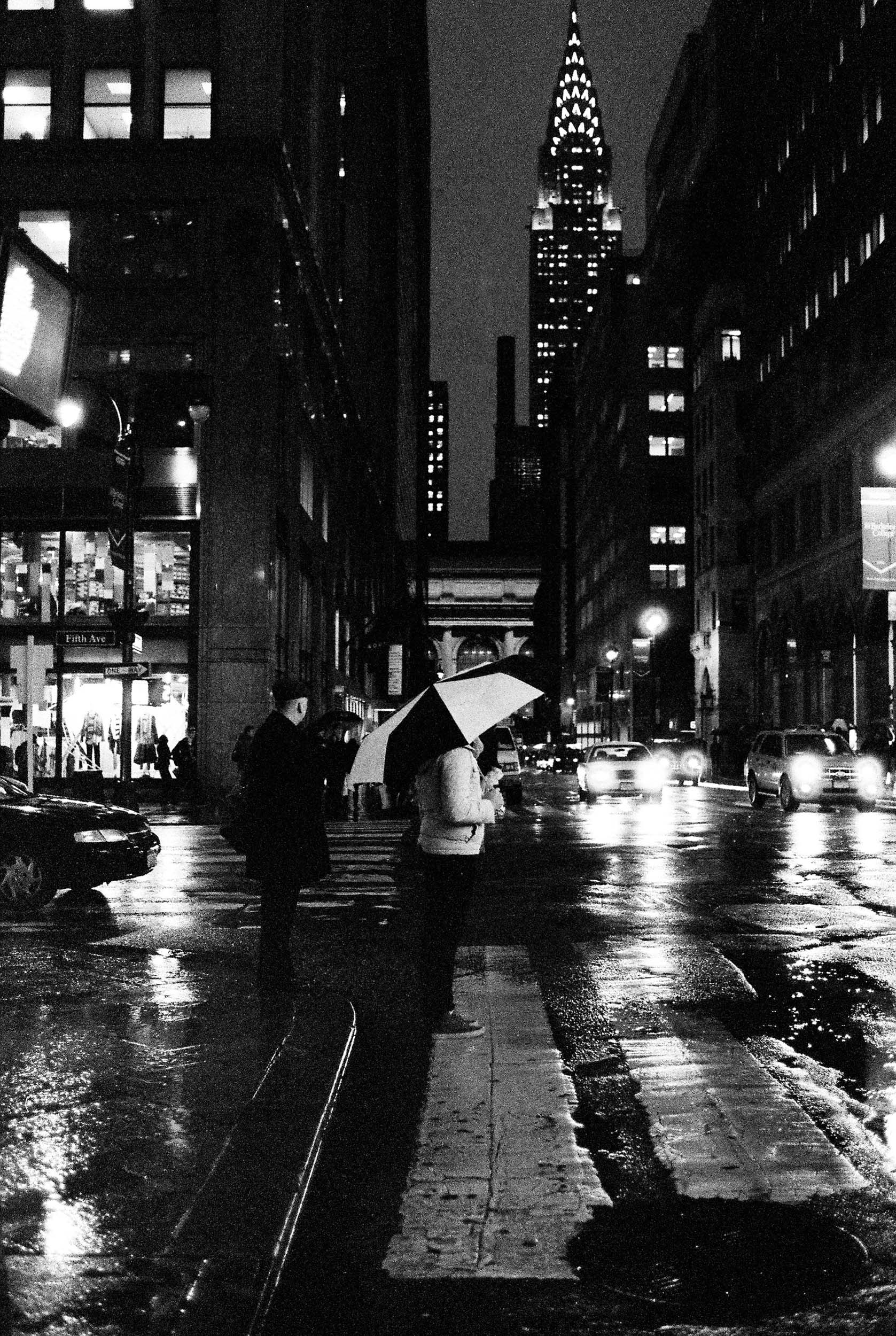 A RAINY GRITTY BLACK AND WHITE FILM PHOTO OF A CROSSWALK IN MIDTOWN MANHATTAN 