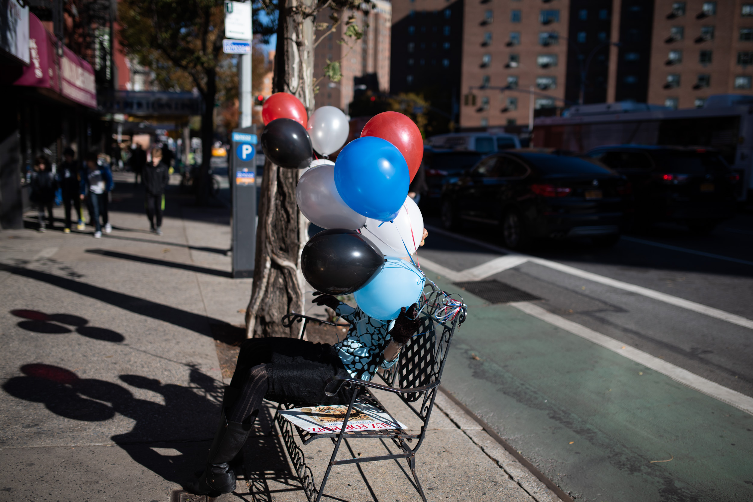 A MAN HOLDING BALLOONS OBSCURES HIS FACE  IN NEW YORK CITY 
