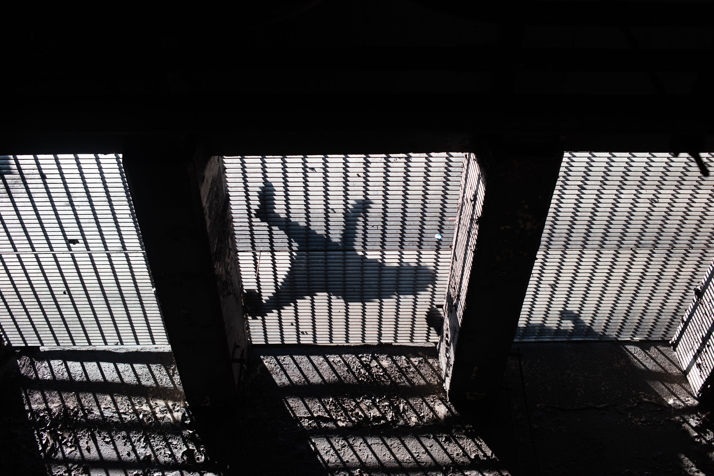 A PERSPECTIVE OF A MAN WALKING ACROSS CITY GRATES OVER THE SUBWAY IN NEW YORK CITY COLUMBUS CIRCLE