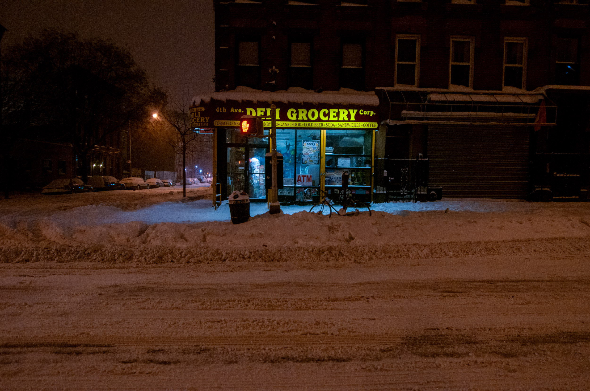 A BODEGA IN DOWNTOWN BROOKLYN ILLUMINATES THE OUTSIDE STREET IN A SNOW STORM
