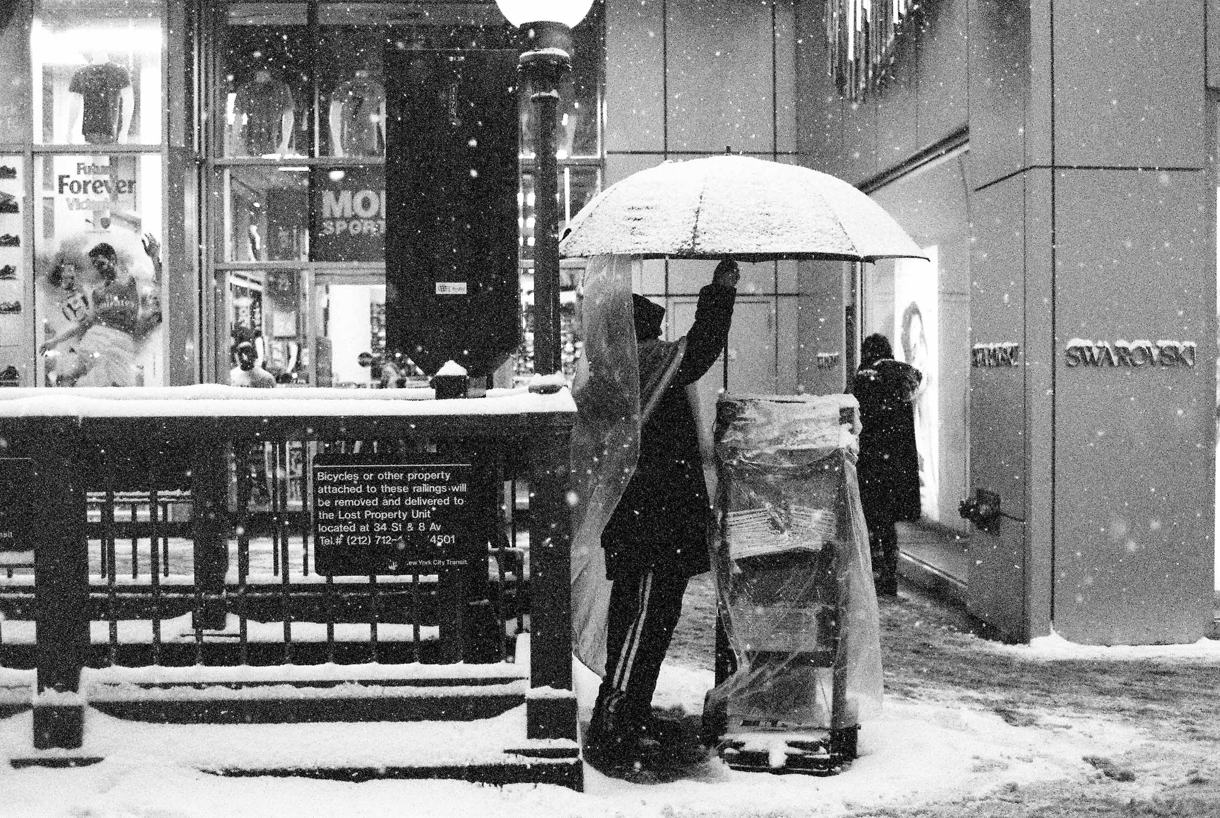A MAN OPENS HIS UMBRELLA IN A SNOW STORM IN MANHATTAN NEW YORK 